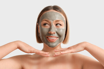 Canvas Print - Mature woman with clay mask on light background, closeup