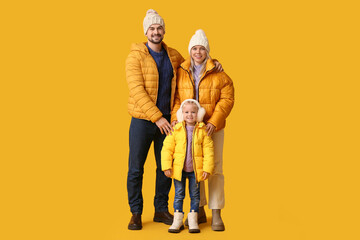 Poster - Happy couple with daughter in winter clothes on yellow background