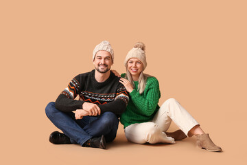 Sticker - Happy couple in winter clothes hugging on beige background