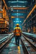 © AdriFerrer - A man in a yellow and orange safety vest walks down a train track