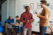 © Sanc/peopleimages.com - Design, tablet and talking with business men in creative workplace together for meeting or planning. Collaboration, conversation or technology with colleague people in office for project discussion