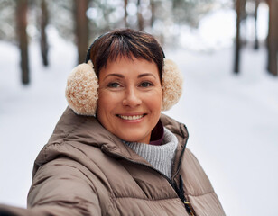 Wall Mural - Smiling Hispanic Woman Winter Portrait in Snow Covered Forest