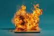 © Joaquin Corbalan - A laptop engulfed in flames on a blue background, illustrating a fire hazard in a modern workspace