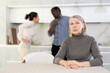 © JackF - Elderly sad woman sits at table during family quarrel between couple woman and man