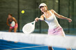 © JackF - Sporty woman playing padel on indoor court on summer day. Sport and active lifestyle concept