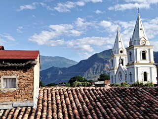 A church with mountains in the background on a sunny day.