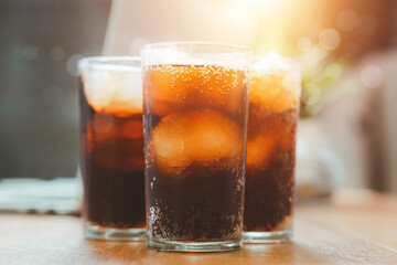 Glass of cola, Double cool ice soft drink cola carbonated liquid fresh food with soda water, Cola drinking with ice in glass ready to refresh you, A cola soft drink is placed on the desk.