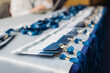 © tsuguliev - Process of checking in on conference congress forum event, registration desk table, visitors and attendees receiving lanyard with name badge and entry wristband bracelet and register electronic ticket