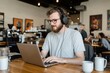 © Level UP - Creative Workspace Digital Nomad Working in Bustling Coffee Shop with Laptop, Headphones, and Artistic Ambiance