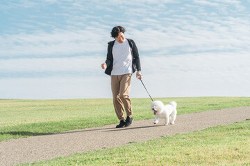 Canvas Print - 犬の散歩をする中年・ミドルの日本人男性（歩く）
