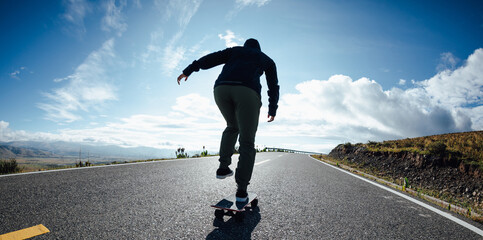 Wall Mural - Skateboarder skateboarding on the mountain road