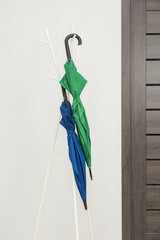 Wall Mural - Colorful umbrellas on clothing rack in hallway