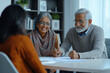 © Nadia Do - Senior married indian couple meeting with a financial or retirement female advisor in the office
