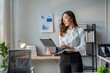 © Wasana - Young asian businesswoman using digital tablet in modern office