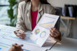 © Wasana - Businesswoman pointing at financial charts during a meeting with colleague