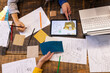 © Wavebreak Media - At office, diverse team using tablet, fabric samples, and sketches on table