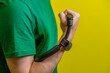 © Anton Dios - A man trains his forearm muscles with a hand grip in front of a yellow background