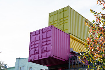 Sticker - A vibrant pink container along with a striking green shipping container has been carefully stacked on top of one another, creating a unique and intriguing visual feature