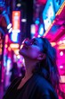 © Box Milk - Female tour guide leading a night tour through a brightly lit city. Neon signs and streetlights illuminate the scene