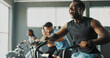 © HockleyM3/peopleimages.com - Activity, exercise bike and training with people in gym together for cardio or intense workout. Elliptical machine, fitness and power with athlete group in health club for challenge or performance