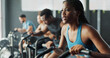 © peopleimages.com - People, fitness and stationary bike at gym for exercise, training and workout with sweat. Cycling machine, energy and building muscles with cardio for health, self care and wellbeing with motivation