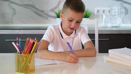 Wall Mural -  An unhappy tired schoolboy boy is doing his homework among stack of books and clutter on his desk. Education, school, learning disability, reading difficulties.