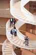 © Johnér - High angle view of colleagues moving down on spiral staircase in office