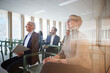 © Johnér - Corporate colleagues attending seminar in office seen through glass