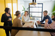 © Johnér - Multiracial corporate employees discussing new ideas while sitting over table in office