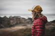 © Johnér - Side view of girl wearing padded jacket and cap at beach