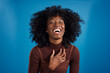 © Johnér - Young businesswoman laughing against blue background