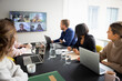 © Johnér - Male and female business colleagues doing virtual meet with team sitting in meeting room
