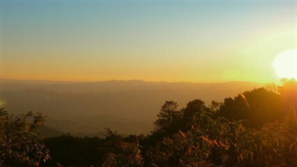 Beautiful Sunset Over Mountain Range, Tranquil Natural Landscape, Golden Horizon, Serene Outdoor Scenery, Warm Sunlight Bathing Nature, Scenic Wilderness Escape. Nature and Tranquility.