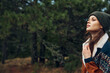 © SHOTPRIME STUDIO - A stylish woman in a fashionable hat and jacket exploring the serene beauty of a lush forest landscape