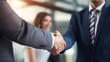 © CottageCore - Two business professionals shaking hands with a cityscape background at sunset.