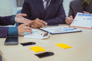 Wall Mural -  Close-up of a businessman in a meeting with a group of businessmen in the office, discussing digital marketing strategies, financial data analysis, and planning business projects together.