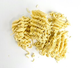 Crushed raw uncooked yellow instant noodle food ingredient photo isolated on horizontal white background.