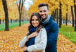 © Celt Studio - Couple in Autumn Park: Man and woman enjoying a peaceful walk in a park filled with trees showcasing vibrant fall colors. dressed in warm clothing, indicating a cool weather setting