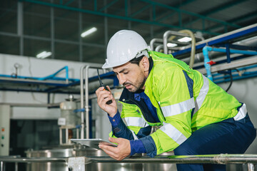 Engineer working, Factory male Latin worker in a oil and gas power plant with control operate order with walkie-talkie communication at work