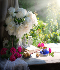 Wall Mural - Bible and a bouquet of peonies on a table in the garden