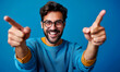© Bartek - Cheerful Young Man Pointing Fingers, Casual Sweater Smiling Portrait, Blue Background Concept of Success, Positivity, Achievement
