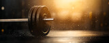 Close-up of a barbell on a gym floor, illuminated by soft light, showcasing strength training and fitness.