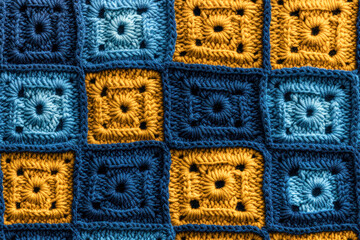 Wall Mural - Close-up of yellow and blue crocheted squares, perfect for textile design or handmade crafts promotion.