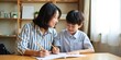 © Reubens Stock Photos - Supportive Asian Mother Assists Son with Homework After School