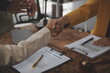 © Sutthicha - Lawyer shaking hands with a client making about documents, contracts, agreements, cooperation agreements with a female client at the lawyer's desk and a hammer at the table.