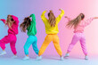 © Robert Kneschke - Five girls dancing hip-hop in vibrant colorful outfits and sneakers on a pastel gradient background, showcasing energy and creativity.