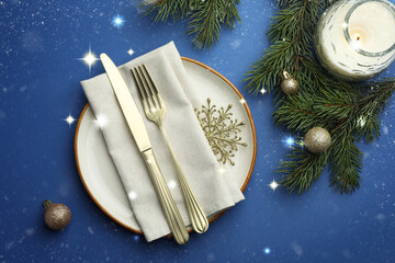 Canvas Print - Beautiful Christmas setting with plate, elegant cutlery and festive decor on blue table, flat lay. Bokeh effect