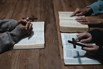 Closeup of simple wooden Christian cross on Bible. Concept of hope, faith, christianity, religion.