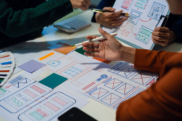 ui designer brainstorming about mobile app interface wireframe design with customer breif and color code at office.