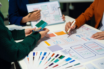 ui designer brainstorming about mobile app interface wireframe design with customer breif and color code at office.